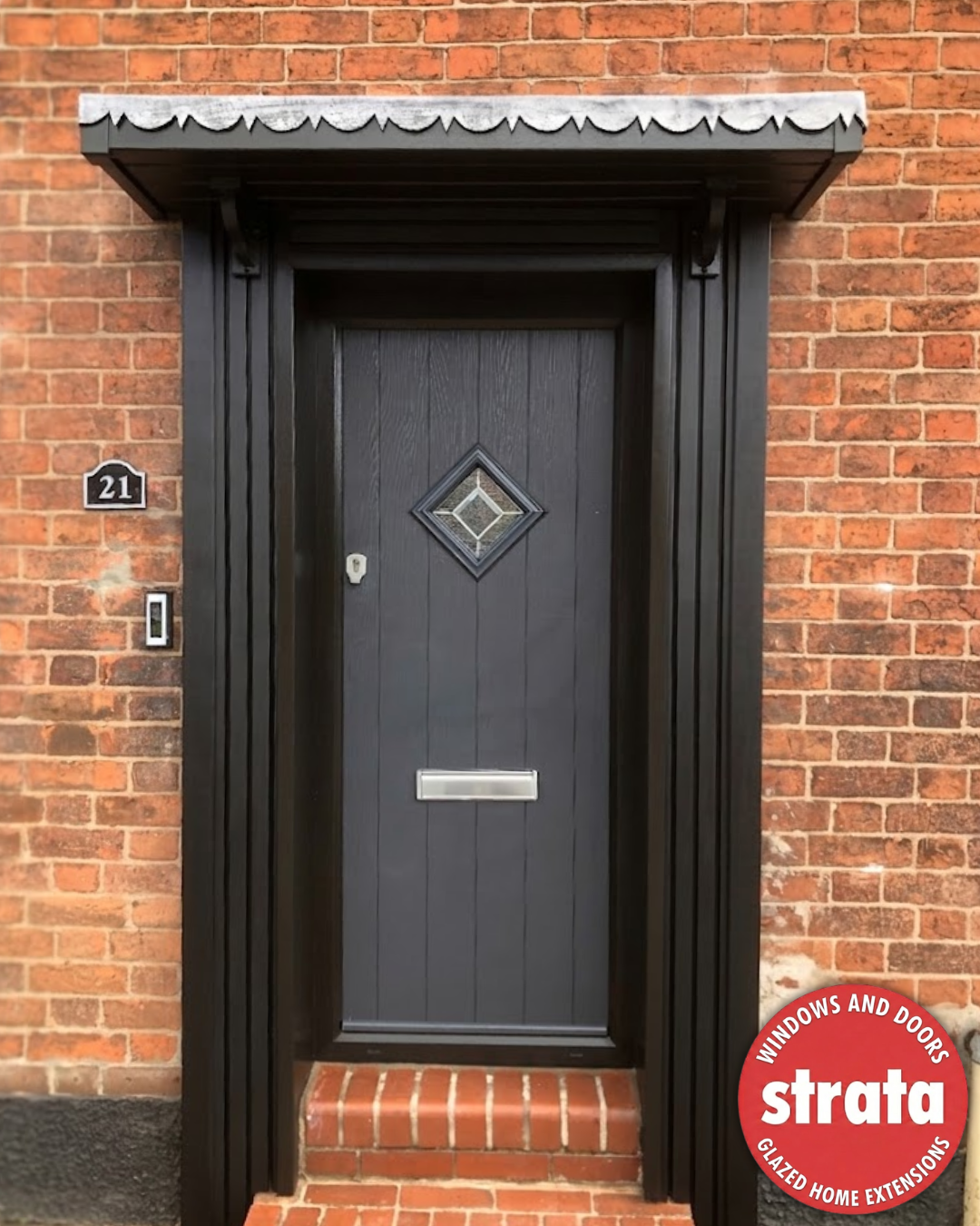 Anthracite grey cottage style composite door with black surround and handcrafted pillars.