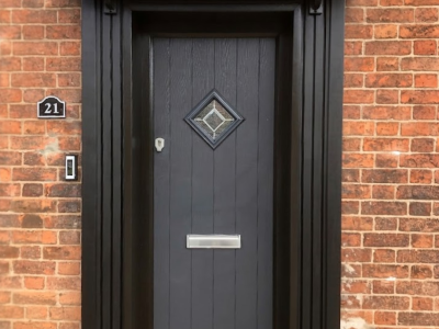 Anthracite grey cottage style composite door with black surround and handcrafted pillars.