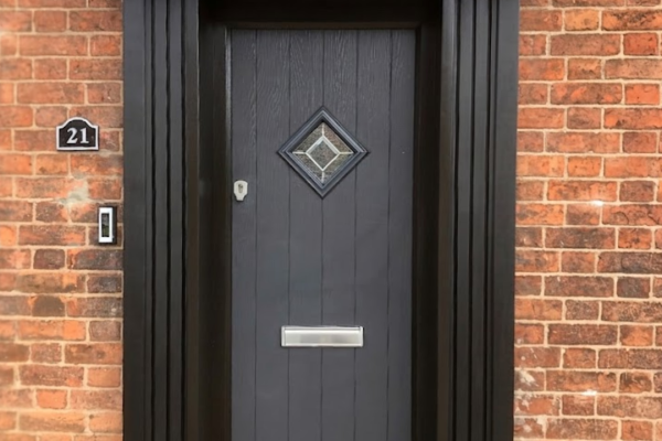 Anthracite grey cottage style composite door with black surround and handcrafted pillars.
